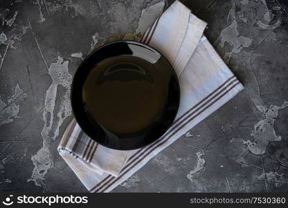 Abstract food background with black plate over gray kitchen table. Abstract food background