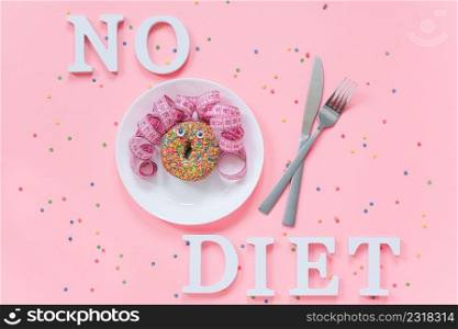 Abstract funny face of woman from donut with eyes and hair from centimeter tape on plate, cutlery and text No diet on pink background. Concept International No Diet Day, 6 may Top view Flat lay.. Abstract funny face of woman from donut with eyes and hair from centimeter tape on plate, cutlery and text No diet on pink background. Concept International No Diet Day, 6 may Top view Flat lay