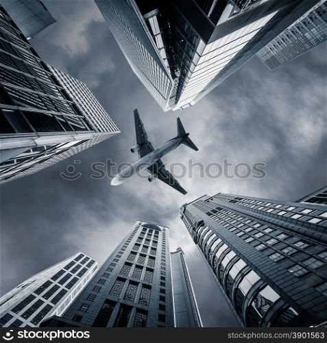 Abstract futuristic cityscape view with airplane flying above modern skyscrapers. Hong Kong