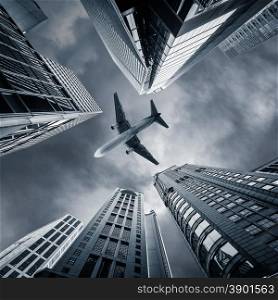 Abstract futuristic cityscape view with airplane flying above modern skyscrapers. Hong Kong