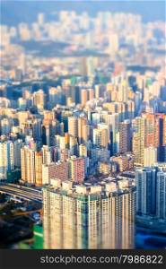 Abstract futuristic cityscape with modern skyscrapers. Hong Kong aerial view evening panorama. Tilt shift effect