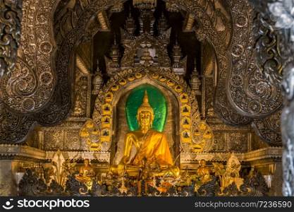 Abstract golden Buddha statue with silver metal frame in temple at Wat Sri Suphan Chiang Mai, Thailand