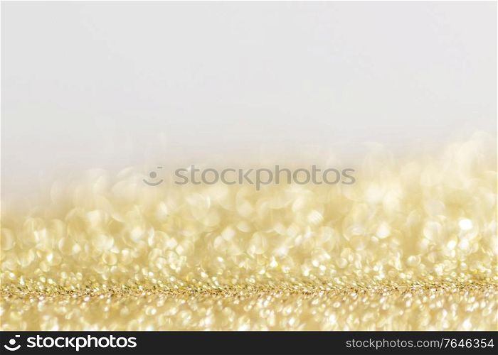 Abstract golden glitter background of shiny lights bokeh Christmas New year celebration luxury party. Abstract golden glitter background