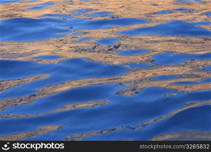 Abstract golden reflection blue water shapes texture background