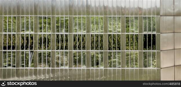 Abstract image of reflecting trees on the glass facade of an office building, Germany