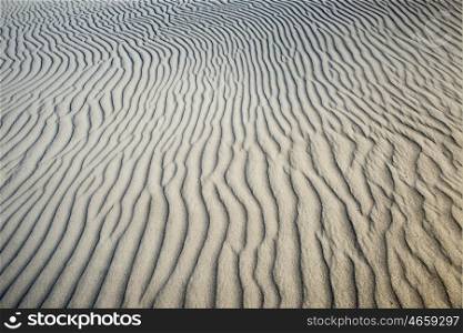 Abstract image of textured beach sand showing the lines created by the wind.