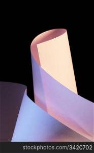 Abstract image of white paper sheets photographed under color lights.