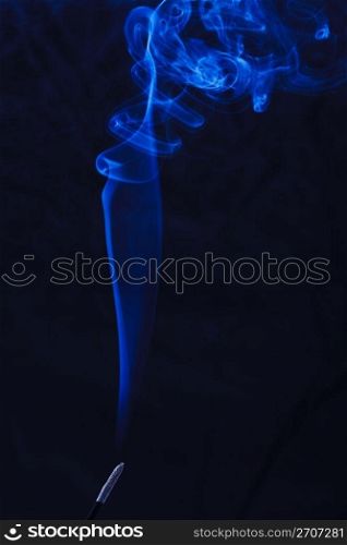 Abstract incense blue smoke against black background
