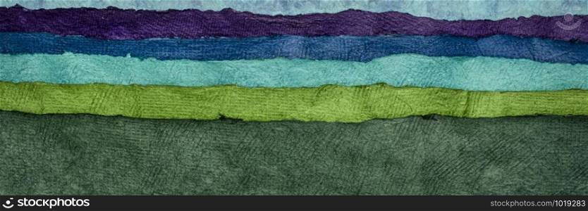 abstract landscape in green and blue tones created with sheets of textured colorful handmade paper, panorama