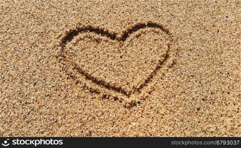 Abstract love symbol drawing on sandy sand beach background