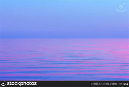 Abstract motion blurred purple blue and pink seascape background. Reflection of the sunset in the flowing water. Space for copy and design.