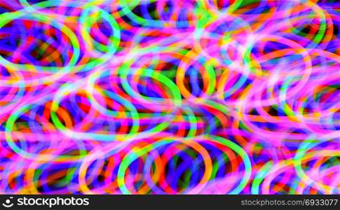 Abstract multi-color light trails shot with long exposure at night. Light painting with circle effect.