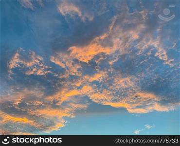 Abstract nature background. Dramatic blue sky with orange colorful sunset clouds in twilight time.
