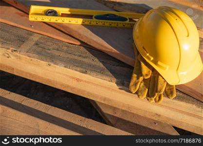 Abstract of Constrcution Hard Hat, Gloves and Level Resting on Wood Planks.