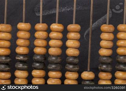 abstract of vintage wooden abacus , beads and rods againsts a blackboard - retro education cocept