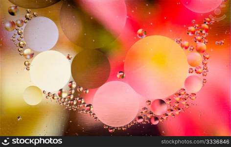 Abstract oil droplets in water reflecting the colors of a background to give a planet effect