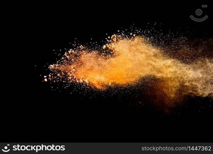 Abstract orange powder explosion isolated on black background.