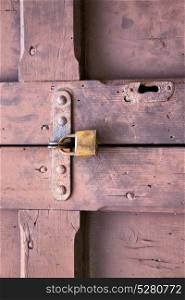 abstract padlock rusty brass brown knocker in a closed wood door crenna gallarate varese italy
