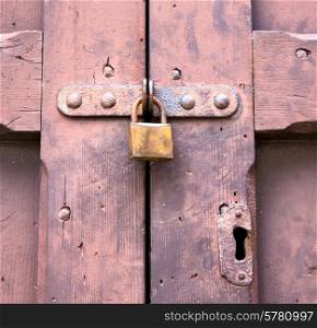 abstract padlock rusty brass brown knocker in a closed wood door crenna gallarate varese italy