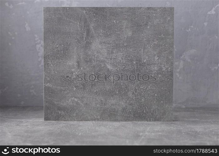 Abstract painted background texture at grey table top. Front view of panel plate as sign near wall at table