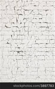 abstract pattern of cracks in old and grungy white washed brick wall