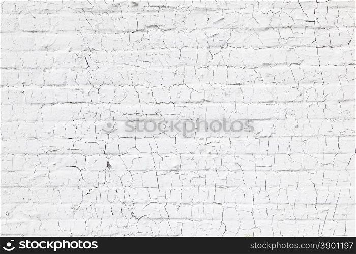 abstract pattern of cracks in old and grungy white washed brick wall