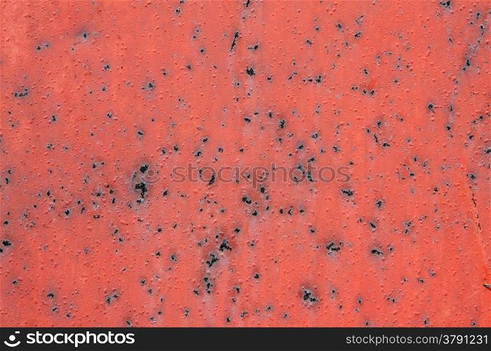 abstract pattern of red painted metal with rusty spots and blisters