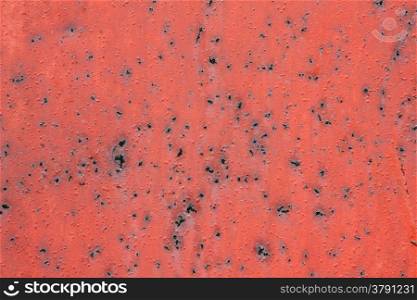 abstract pattern of red painted metal with rusty spots and blisters