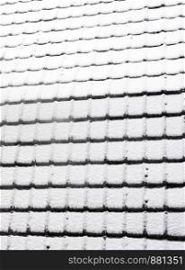 abstract pattern of snow covered roof tiles in winter