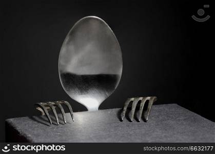 Abstract person from spoon and forks on black background
