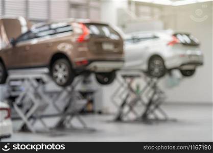 Abstract photo blurred of Car lift in automobile service or maintainance service center which is a part of showroom, technician or professional work for customer concept