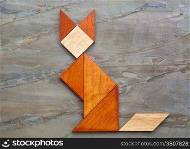 abstract picture of a cat built from seven tangram wooden pieces against slate rock background, a traditional Chinese puzzle game, the artwork copyright by the photographer