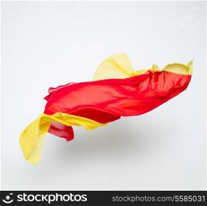 abstract pieces of red and yellow fabric flying, studio shot, design element