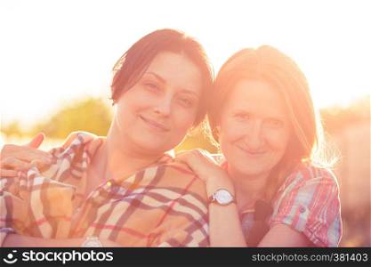 abstract portrait of two smiling girls against the sunset beams