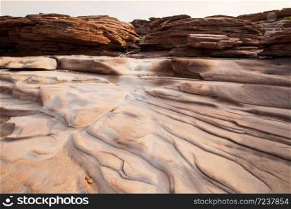 Abstract ripples of sedimentary sandstone on the Mekong River in summer, art shape of lines and pebbles on sandstone, balance and harmony. Zen meditation in nature.