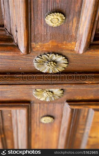 abstract rusty brass brown knocker in a closed wood door crenna gallarate varese italy