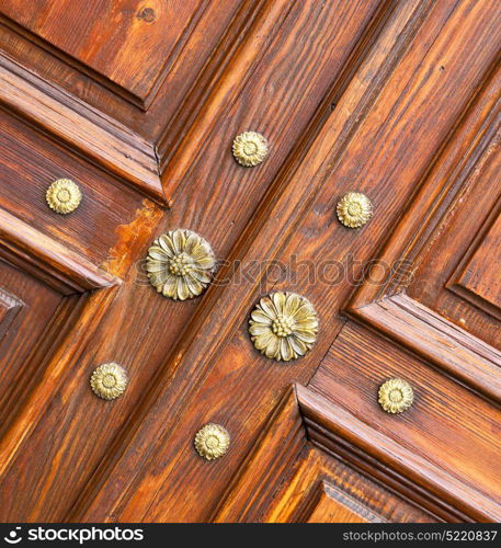 abstract rusty brass brown knocker in a closed wood door crenna gallarate varese italy