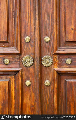 abstract rusty brass brown knocker in a closed wood door crenna gallarate varese italy