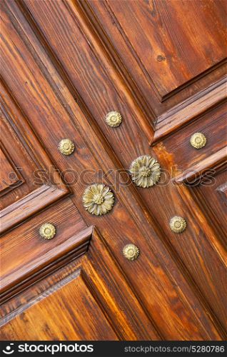 abstract rusty brass brown knocker in a closed wood door crenna gallarate varese italy