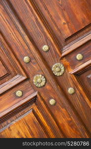 abstract rusty brass brown knocker in a closed wood door crenna gallarate varese italy