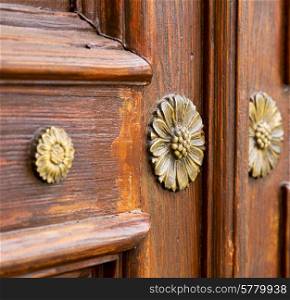 abstract rusty brass brown knocker in a closed wood door crenna gallarate varese italy&#xA;