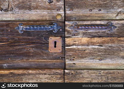 abstract rusty brass brown knocker in a closed wood door mornago varese italy