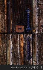 abstract rusty brass brown knocker in a closed wood door mornago varese italy