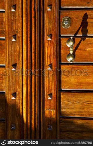 abstract rusty brass brown knocker in a closed wood door olgiate olona varese italy