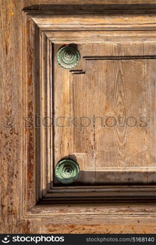 abstract rusty brass brown knocker in a door curch closed wood lombardy italy varese lonate pozzolo