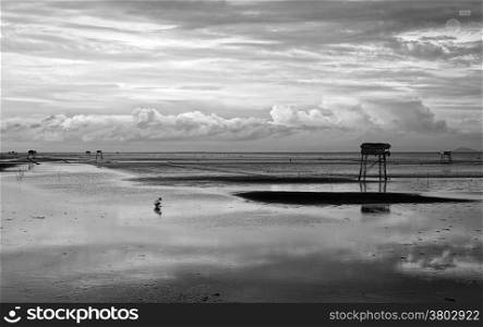 Abstract scene lonely man on Vietnam beach under cloudy sky, watch tower on black sand at Mekong Delta beach