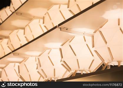 Abstract shape table lamp with warm light on display shelf at modern furniture store.