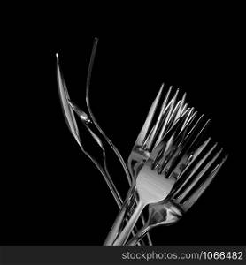 Abstract shapes with flatware on black background