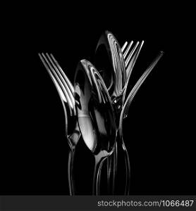 Abstract shapes with flatware on black background