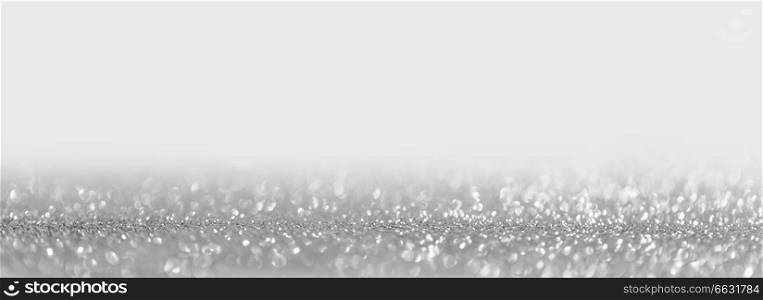 Abstract shining glitters silver on white holiday bokeh background with copy space for text. Abstract silver background